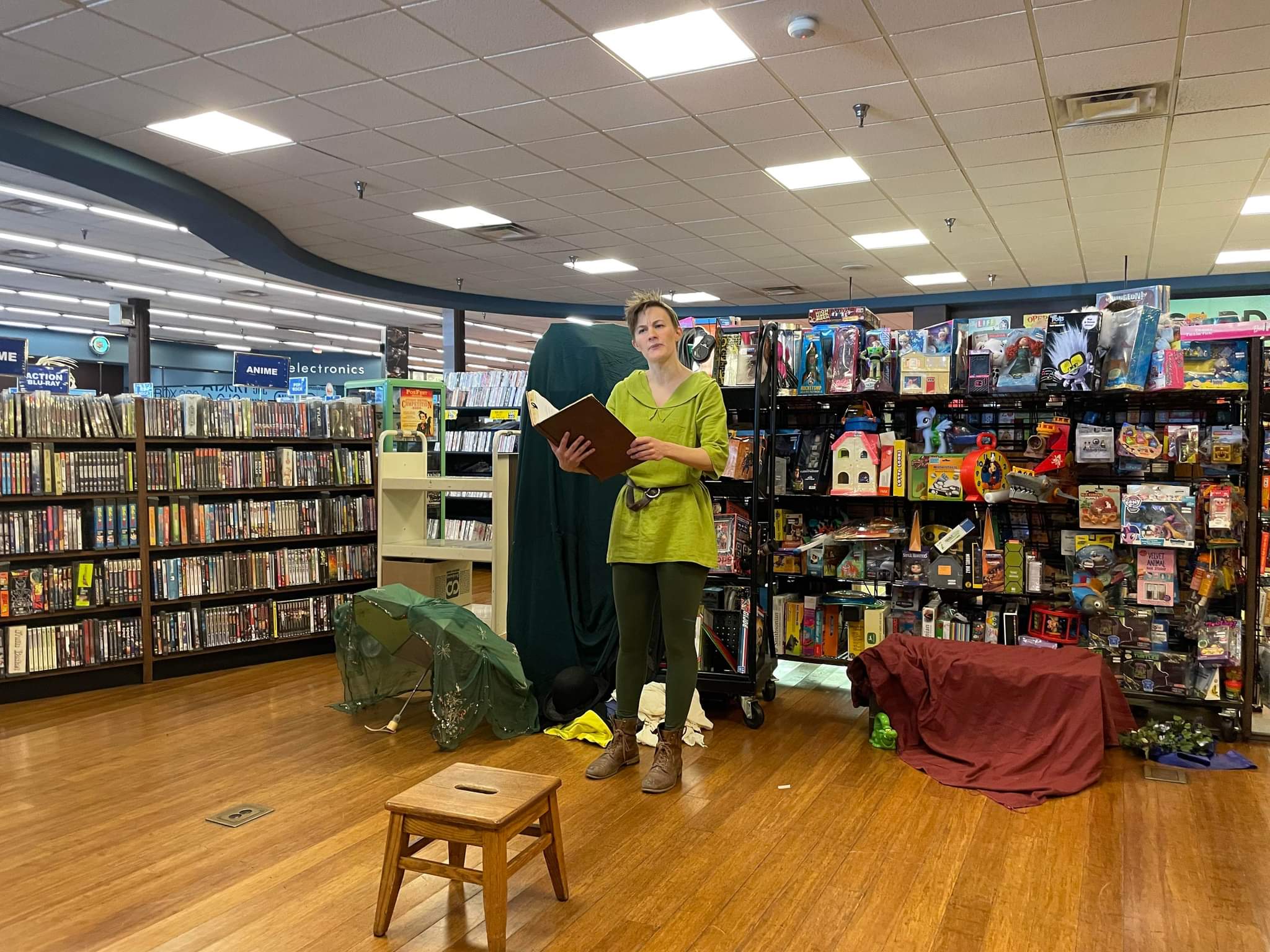person dressed as Peter Pan in front of bookshelves